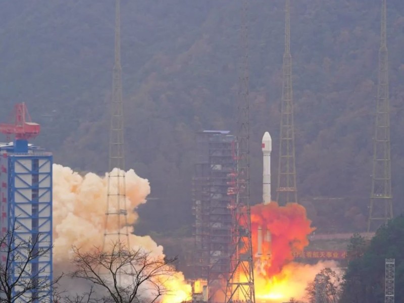 A rocket lifts off from a launch tower, with a plume of fire and smoke billowing beneath.