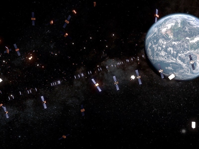 An illustration showing GEO being crowded, as Earth is blanketed by an orbit of satellites and debris.